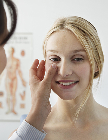 patient having her skin evaluated by a doctor