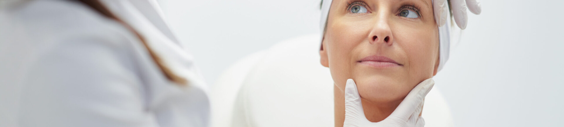 A scene of a doctor checking a patient's facial skin